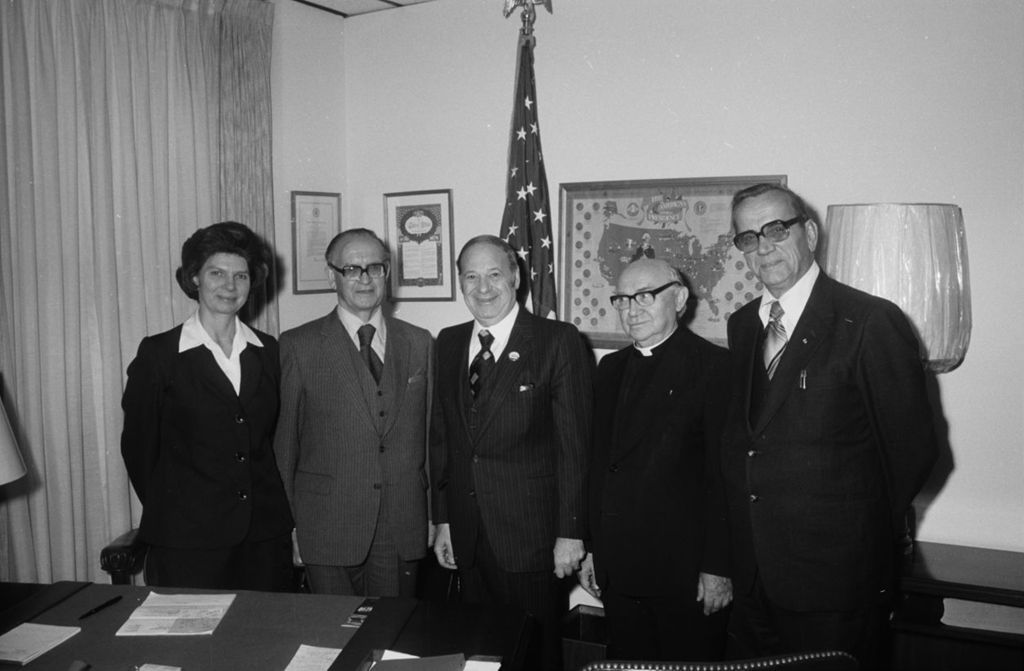 Congressman Frank Annunzio and others standing near a desk