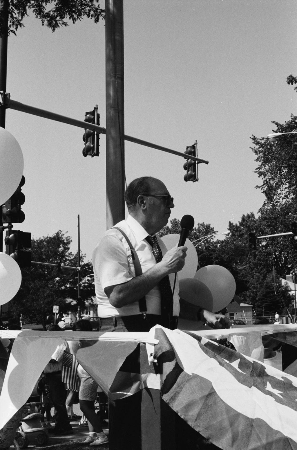 Man speaking from podium at Fourth of July Parade