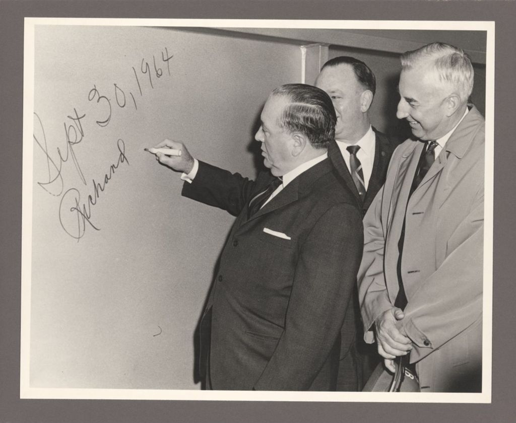 Miniature of Richard J. Daley signing his name on a wall