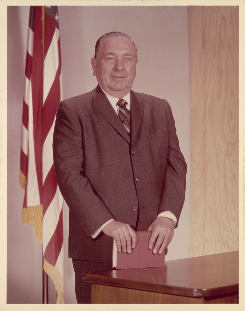 Richard J. Daley with a book and a flag