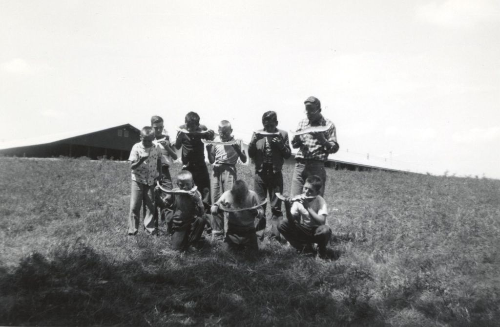 Boys eating watermelon on a hillside