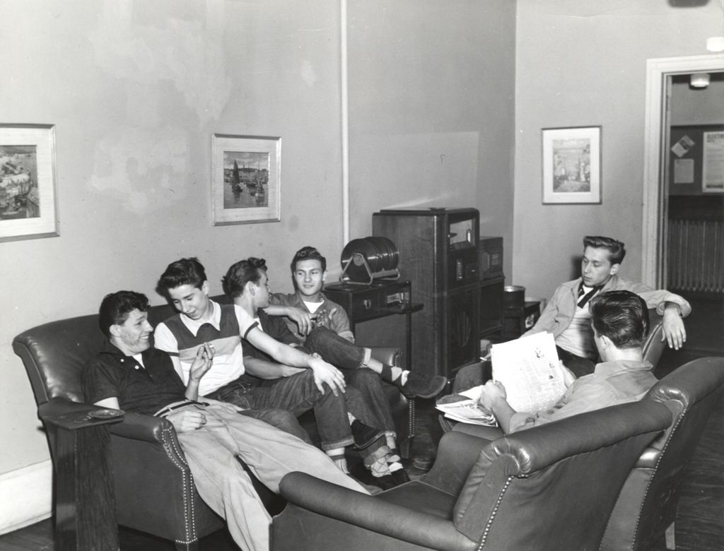 Teenage boys relaxing on couches in room with stereo
