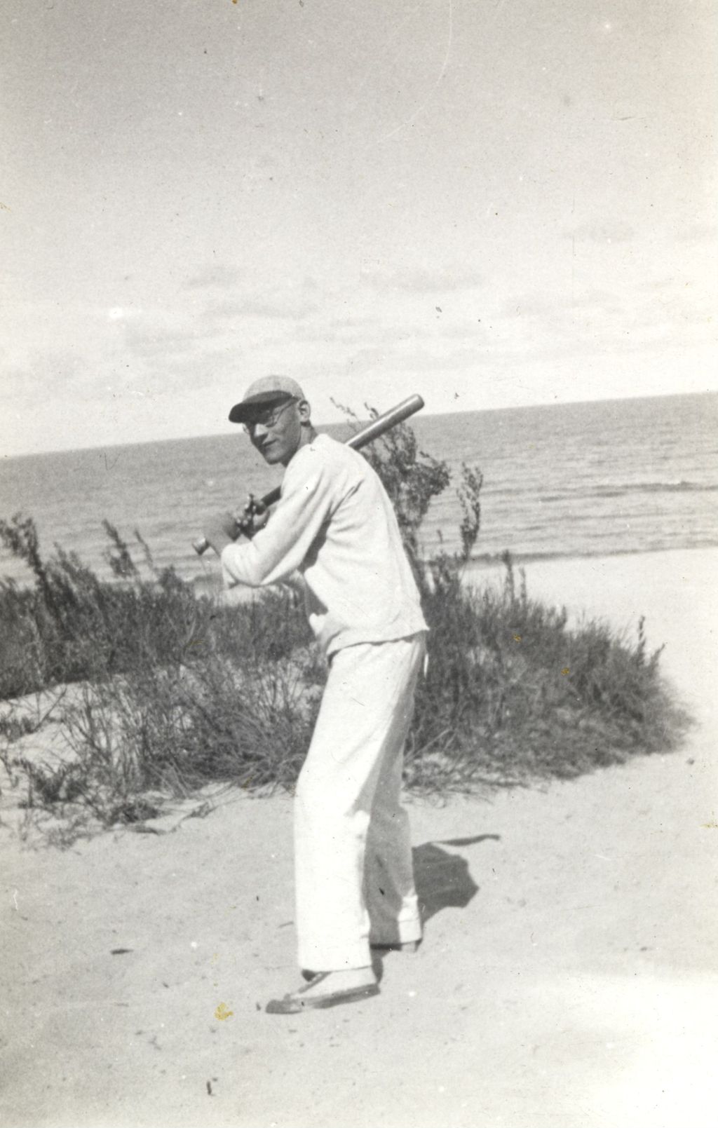 Man holding a baseball bat at the lakeshore
