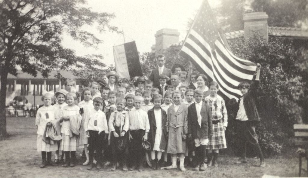 Children with Bohemian Settlement House banner and flag