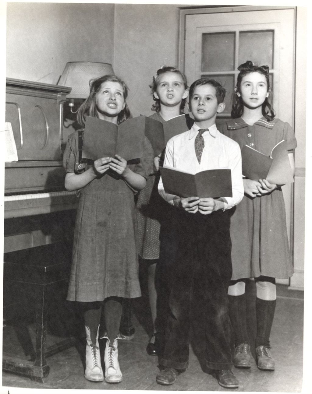 Children singing next to piano
