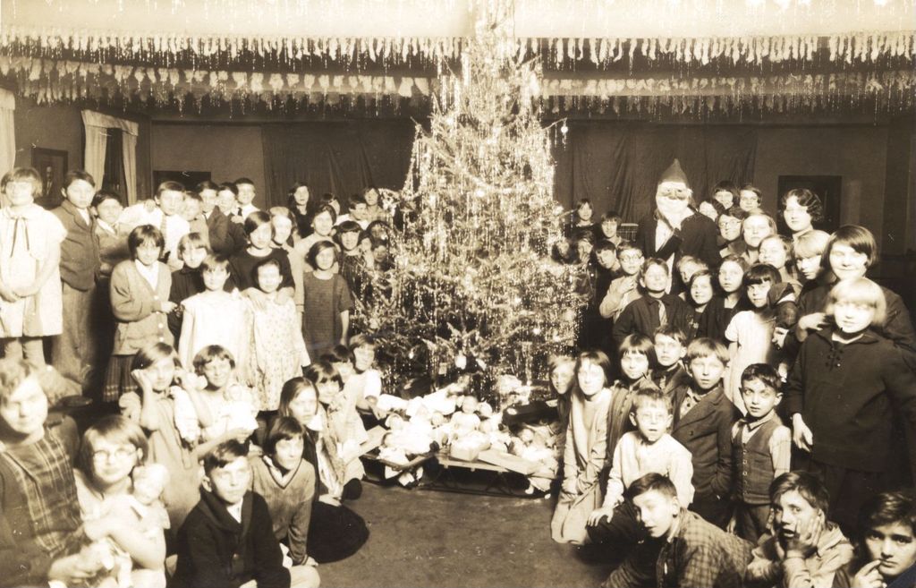 Children around a Christmas tree with Santa