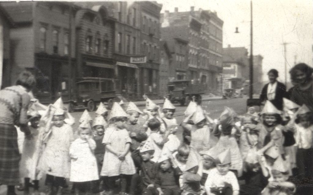 Children in party hats on street with teachers