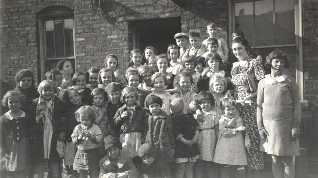 Children and teacher outside a building