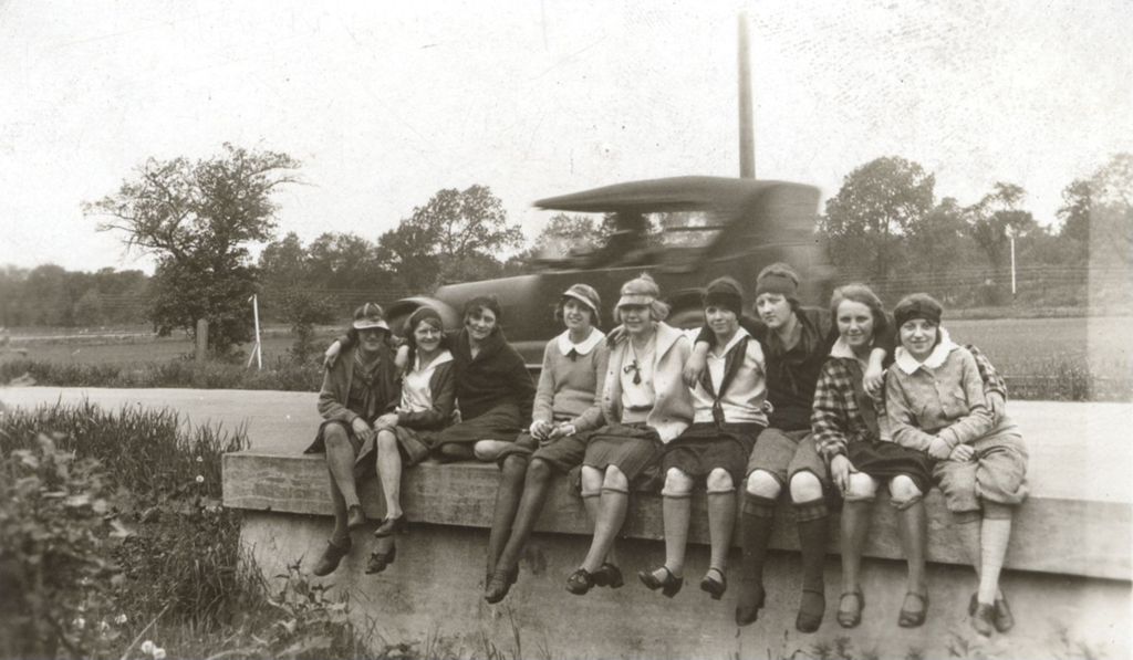 Girls seated along the side of road
