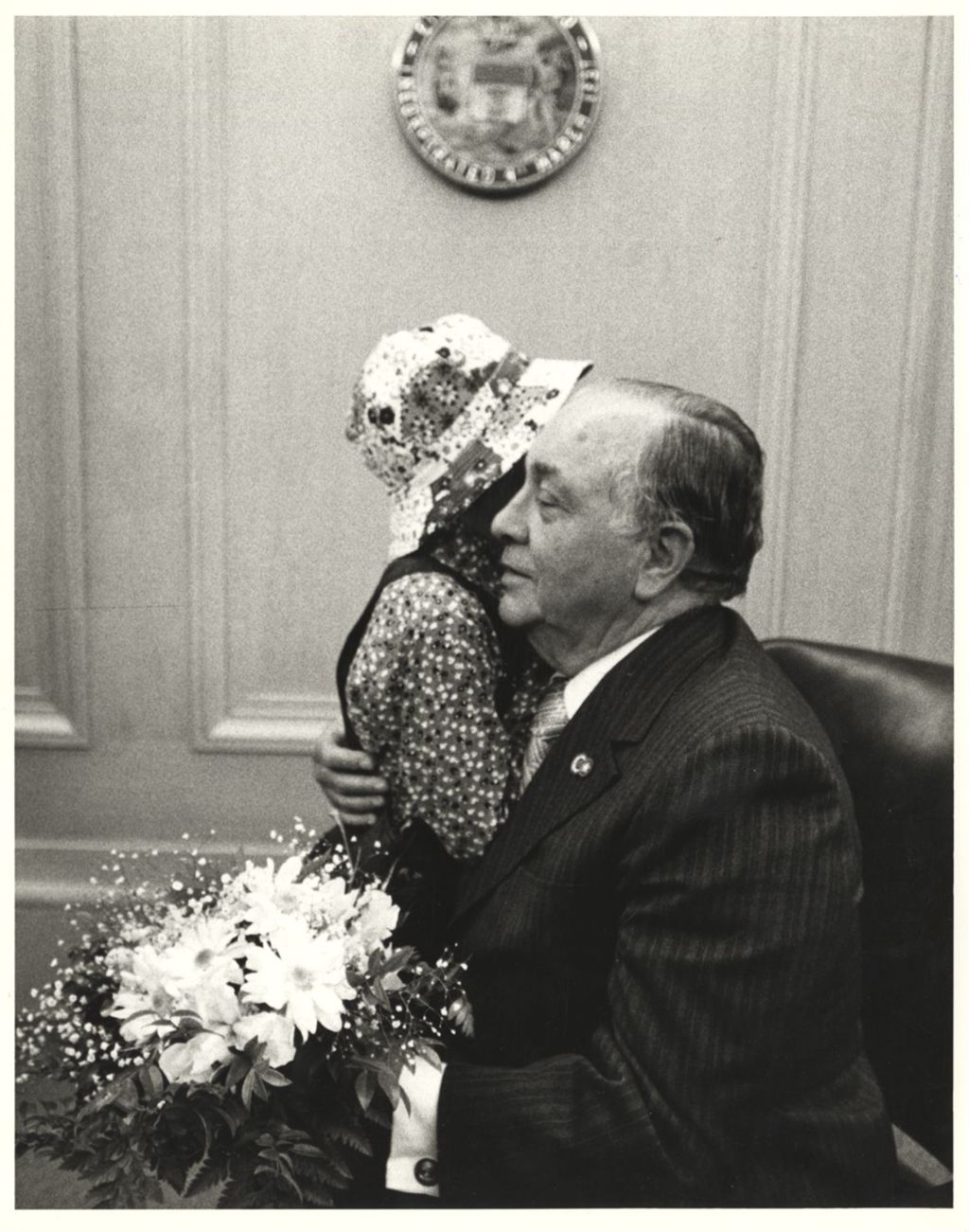 Miniature of American Cancer Society representative hugs Richard J. Daley