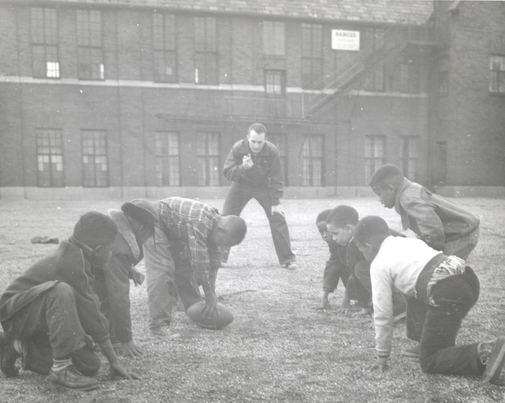 Group of boys playing football with a referee