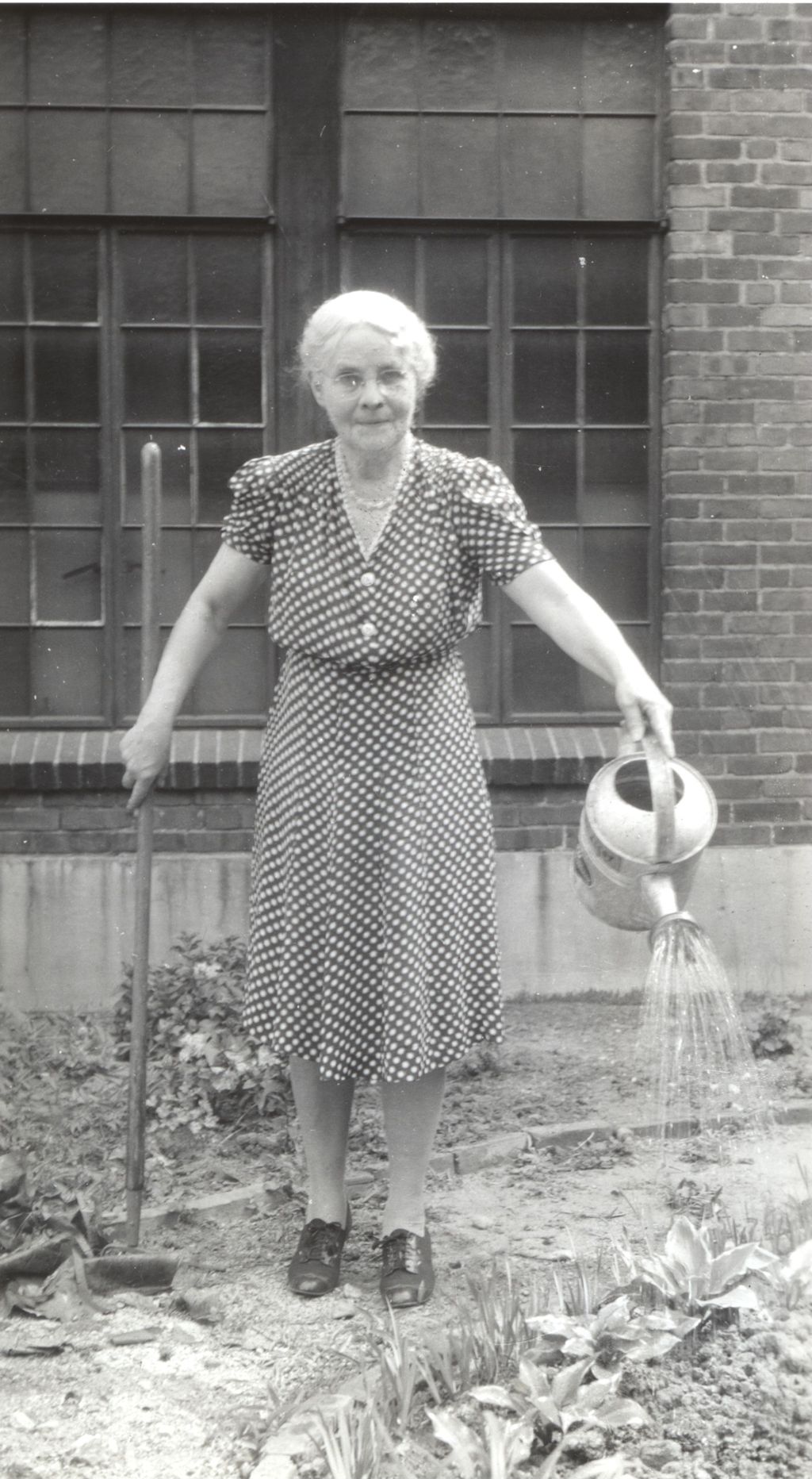 Harriet Seeds watering plants outside Marcy Center