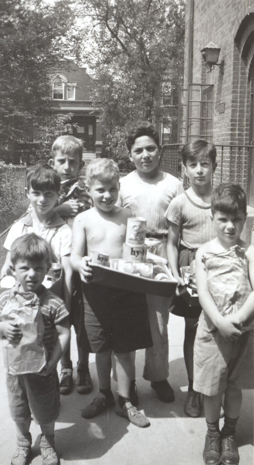 Boys outside Marcy Center with tin cans for salvage drive