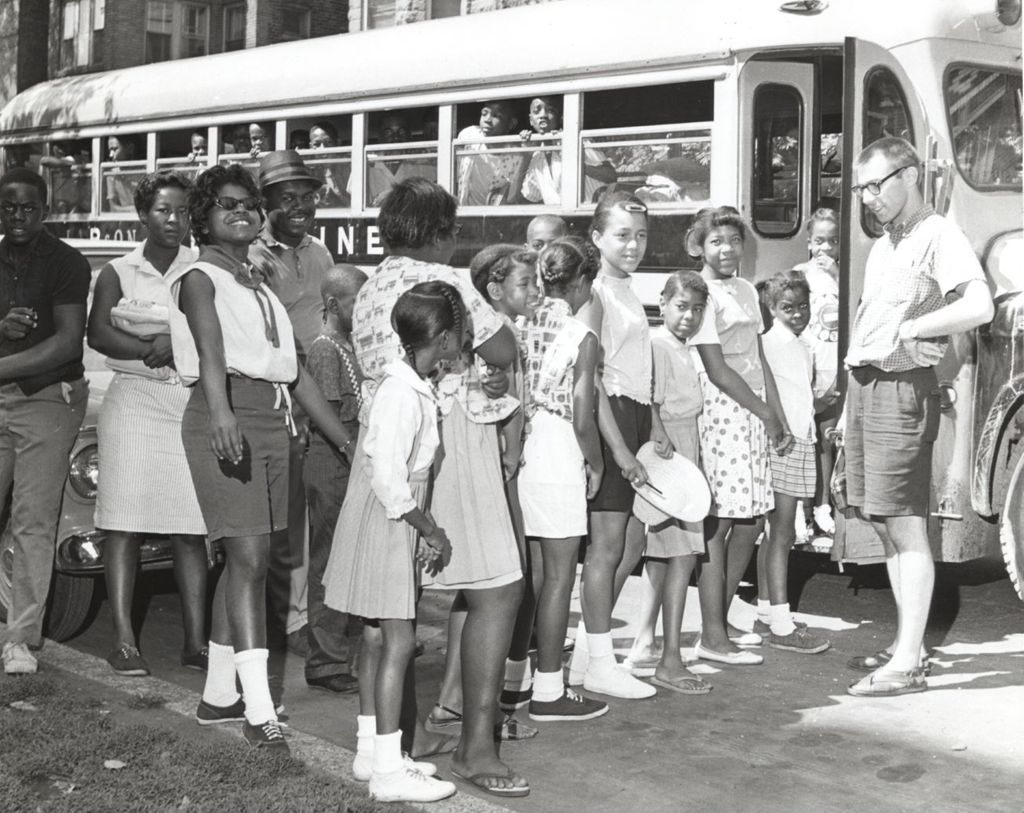 Children and teenagers boarding a bus for a field trip