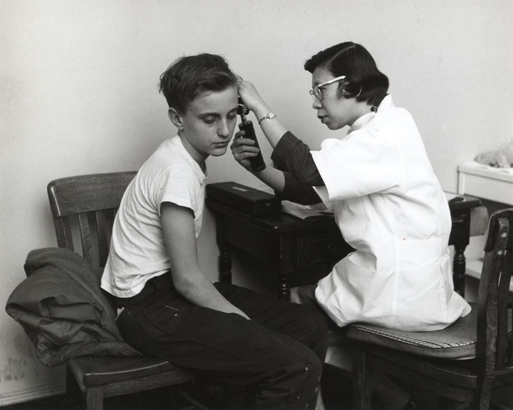 Miniature of Dr. Lucinda Rita examining boy's ear, Marcy Center Clinic