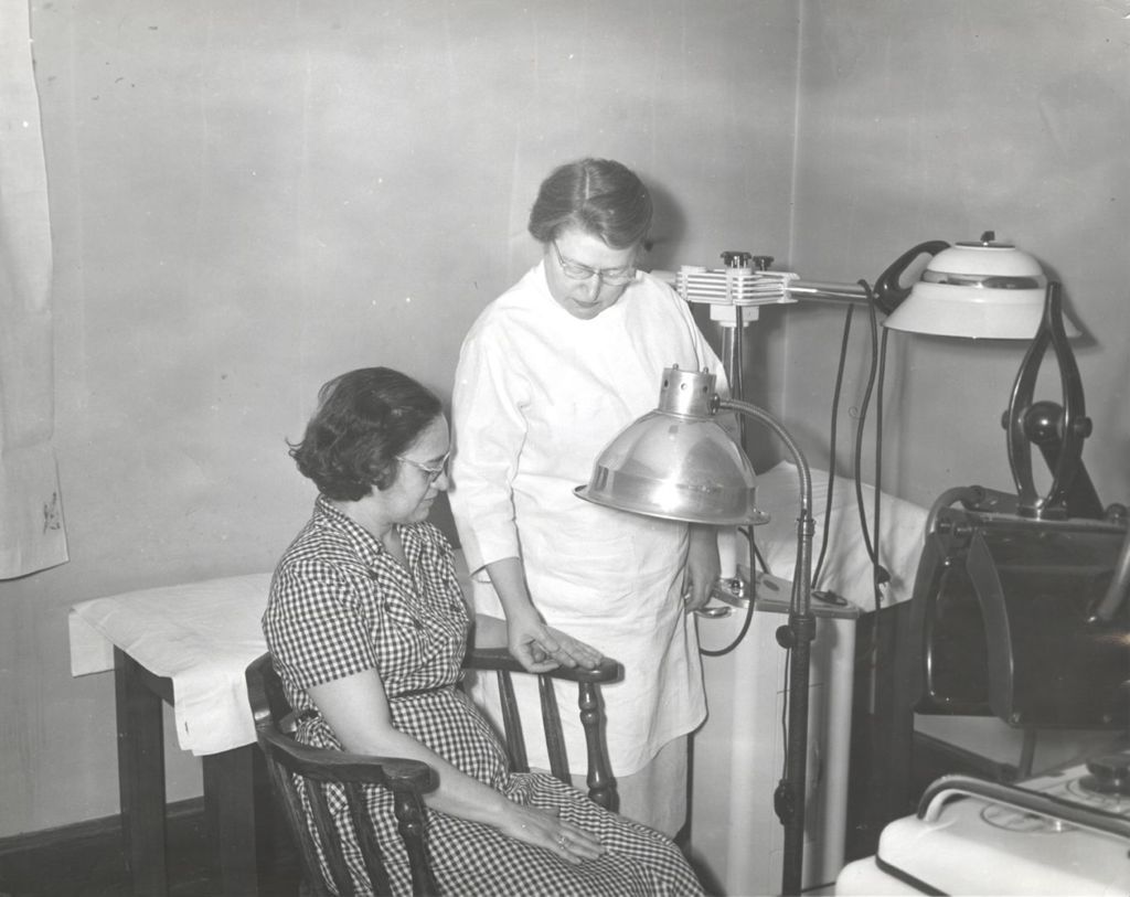 Nurse examining a patient's hand at the Marcy Center Clinic