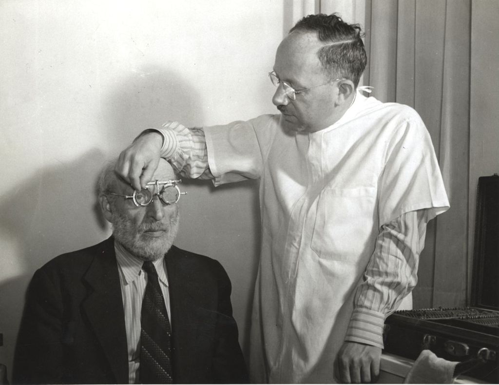 Doctor giving eye test to an older man