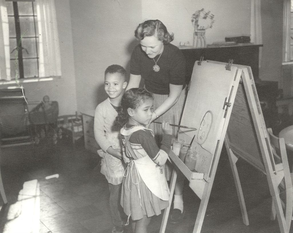 Nursery teacher Ramona Heindt with children at an easel