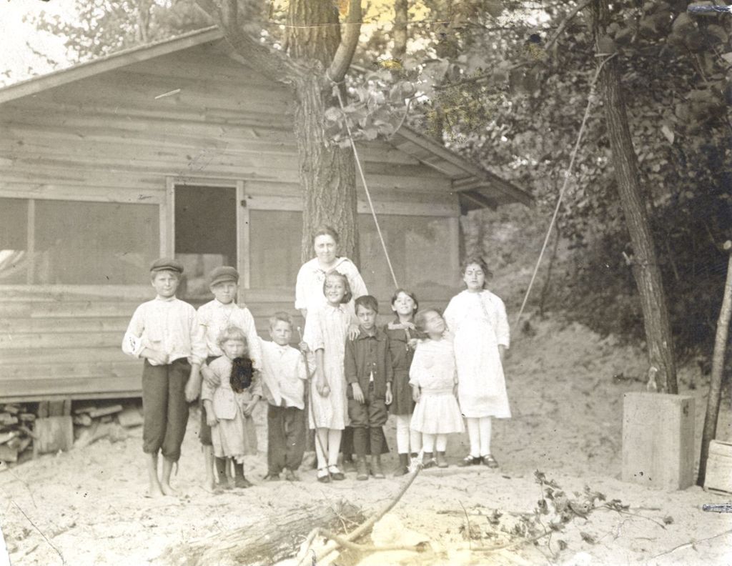 Children and woman outside a camp cabin