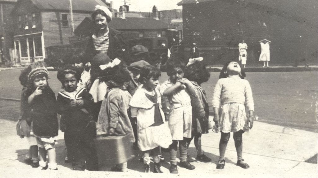Woman and young children on a sidewalk