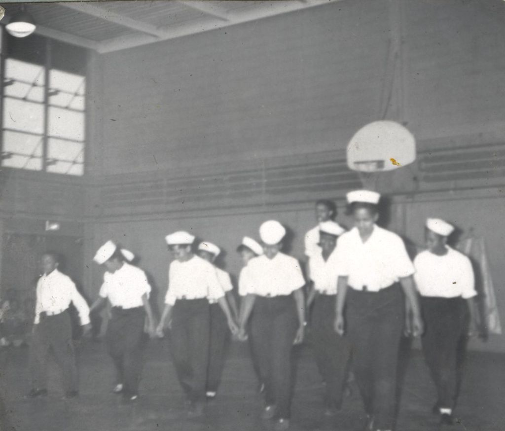 Children in uniforms performing in a gym