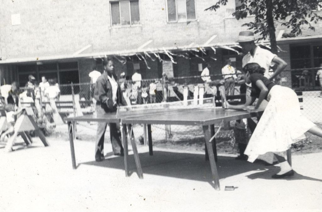 Teenagers playing ping-pong outside a building