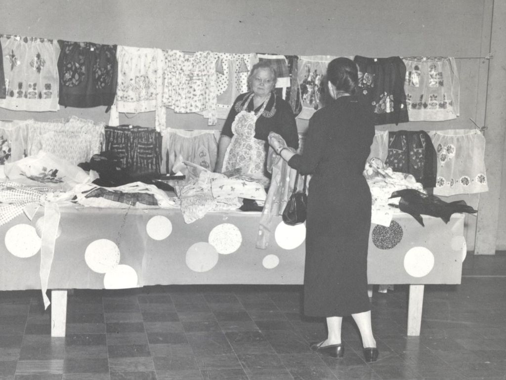 Miniature of Woman examining garments for sale