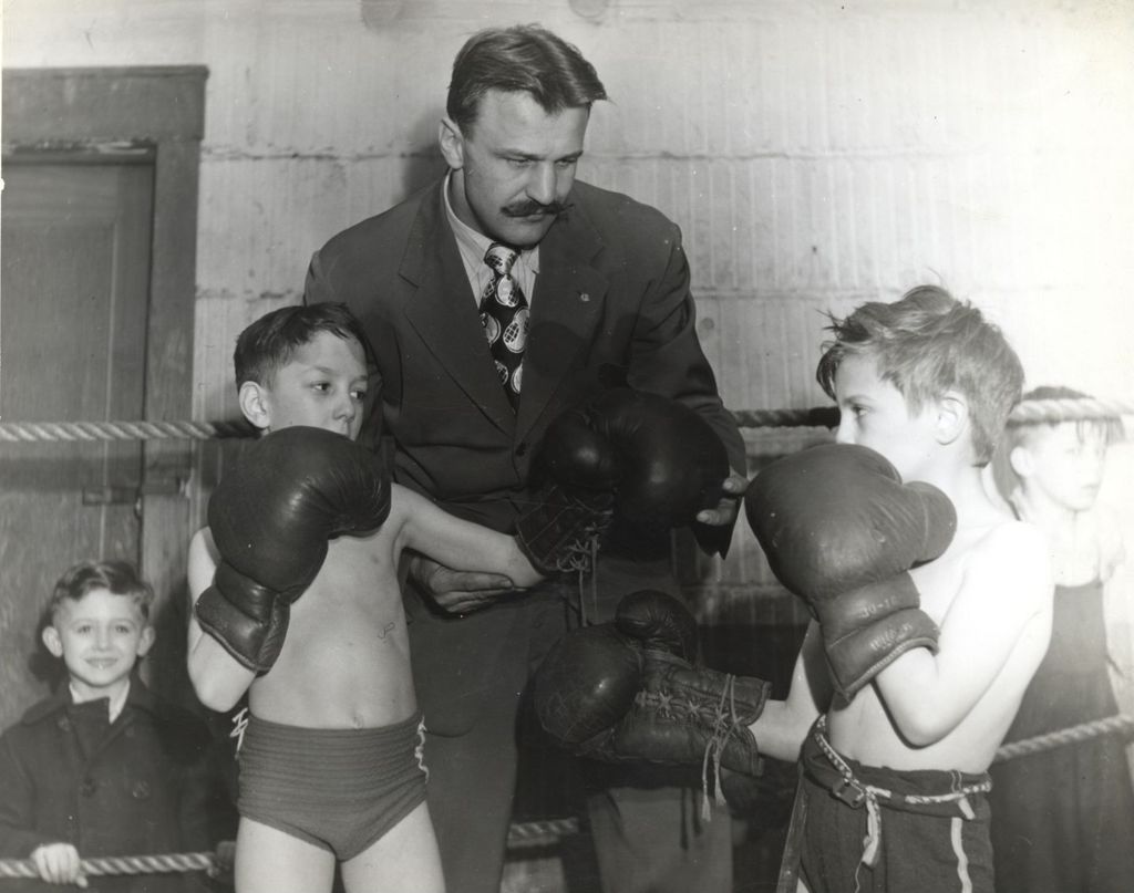 Young boys in boxing gloves sparring in the ring