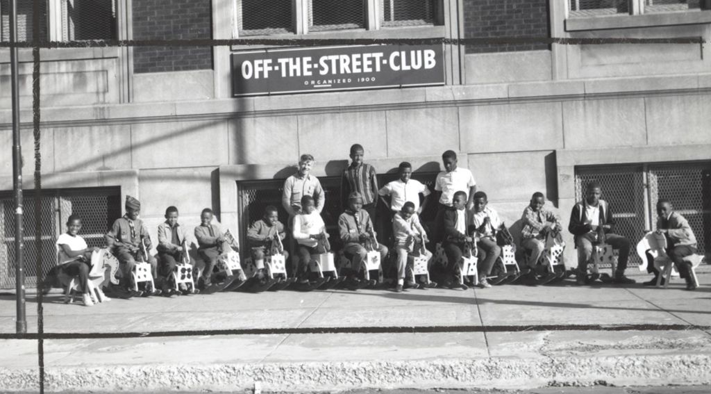 Children on rocking horses in front of the Off-The-Street Club