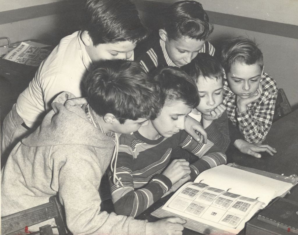 Boys looking at a stamp collection