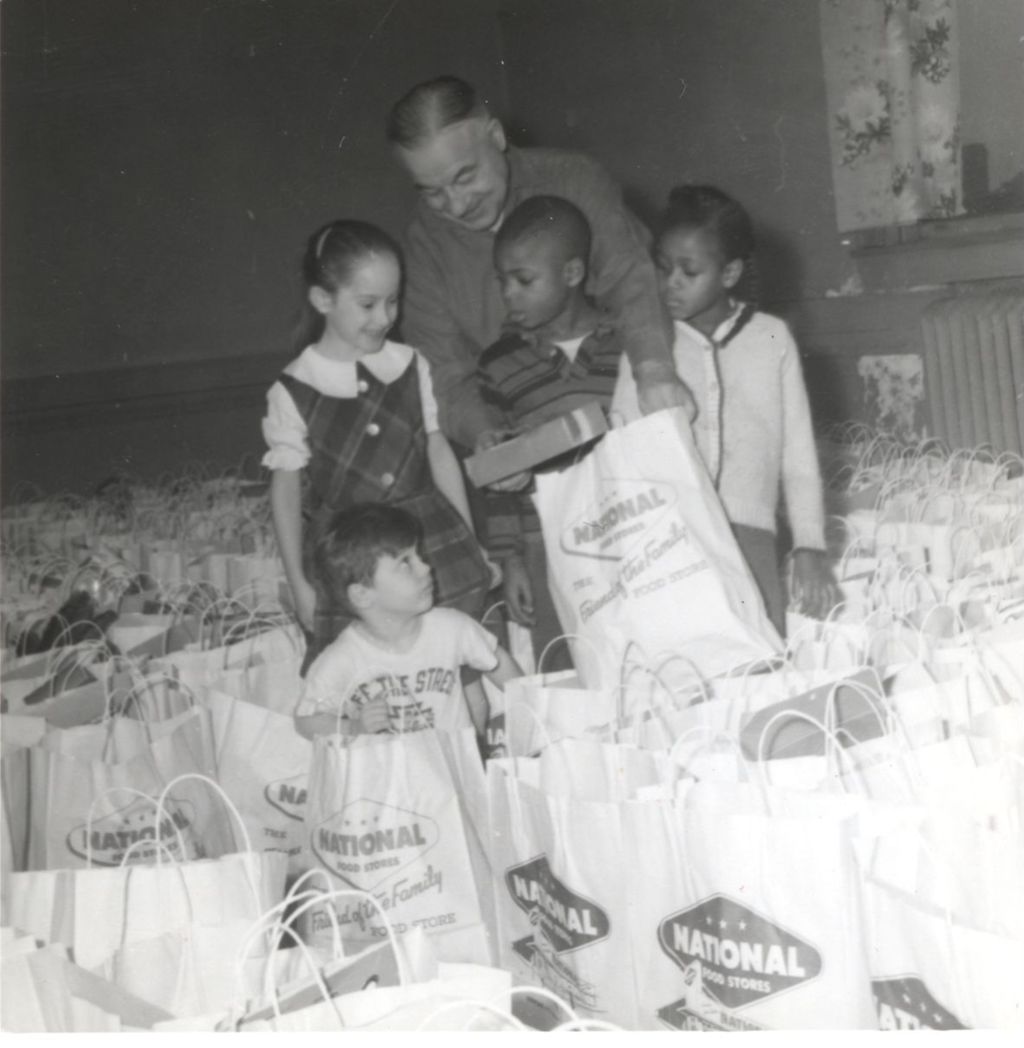 Auguste Mathieu and children with bags of donated presents