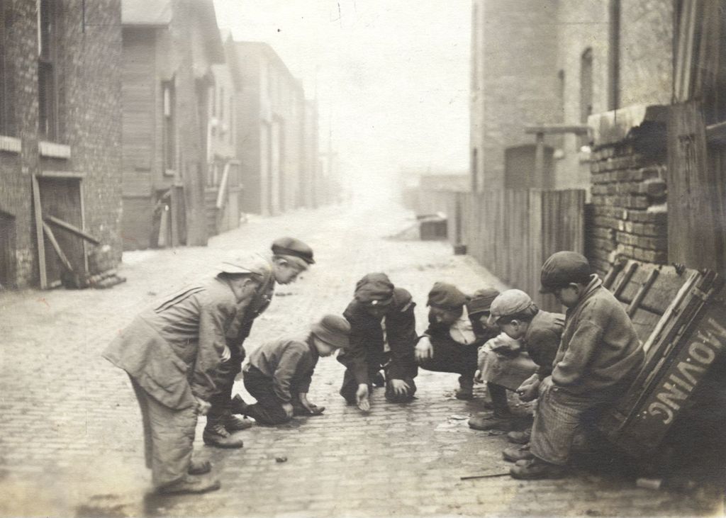Boys playing dice in an alley