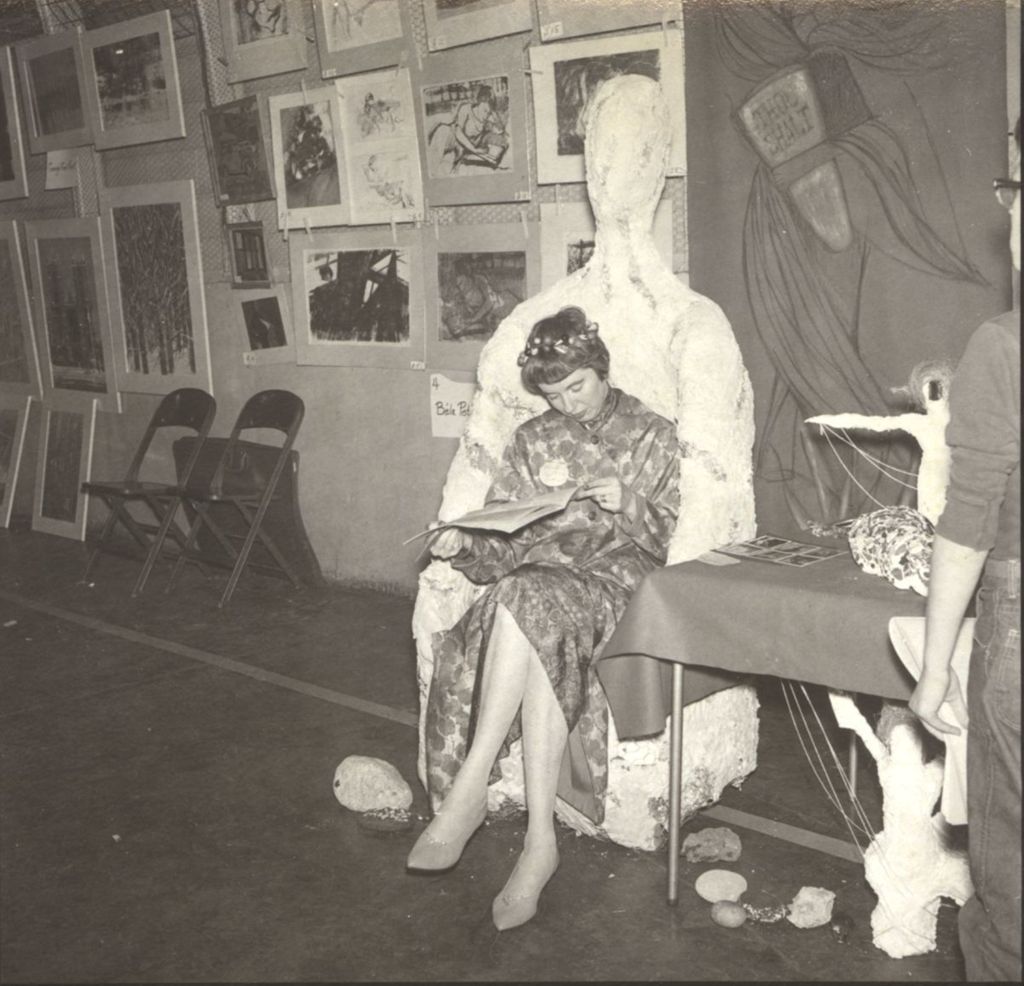 Woman reading in chair at art exhibition