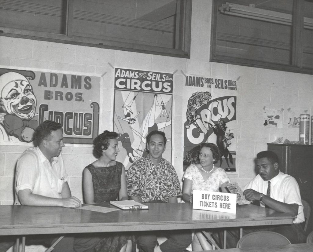Group of adults selling circus tickets