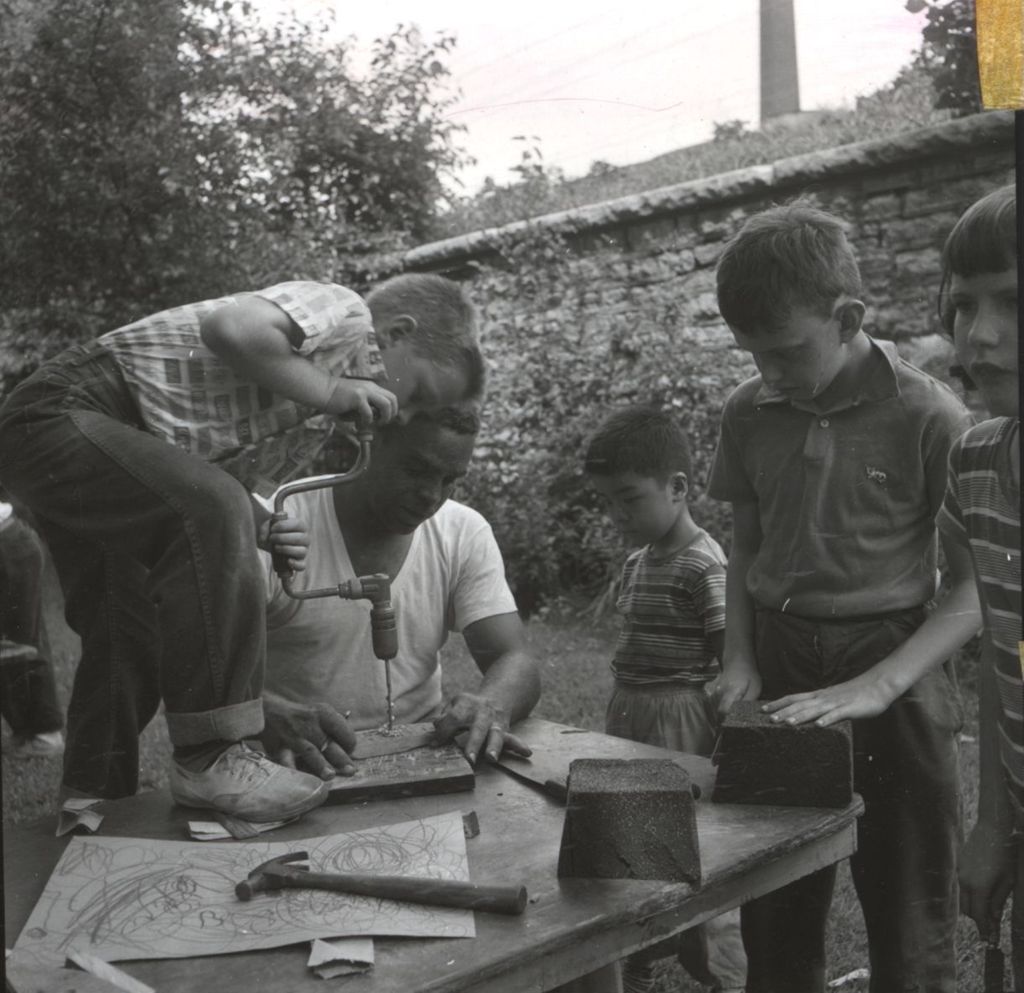 Group of children learning woodworking from an instructor