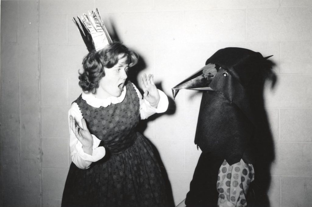 Teenage girl miming a frightened response to actor in bird costume