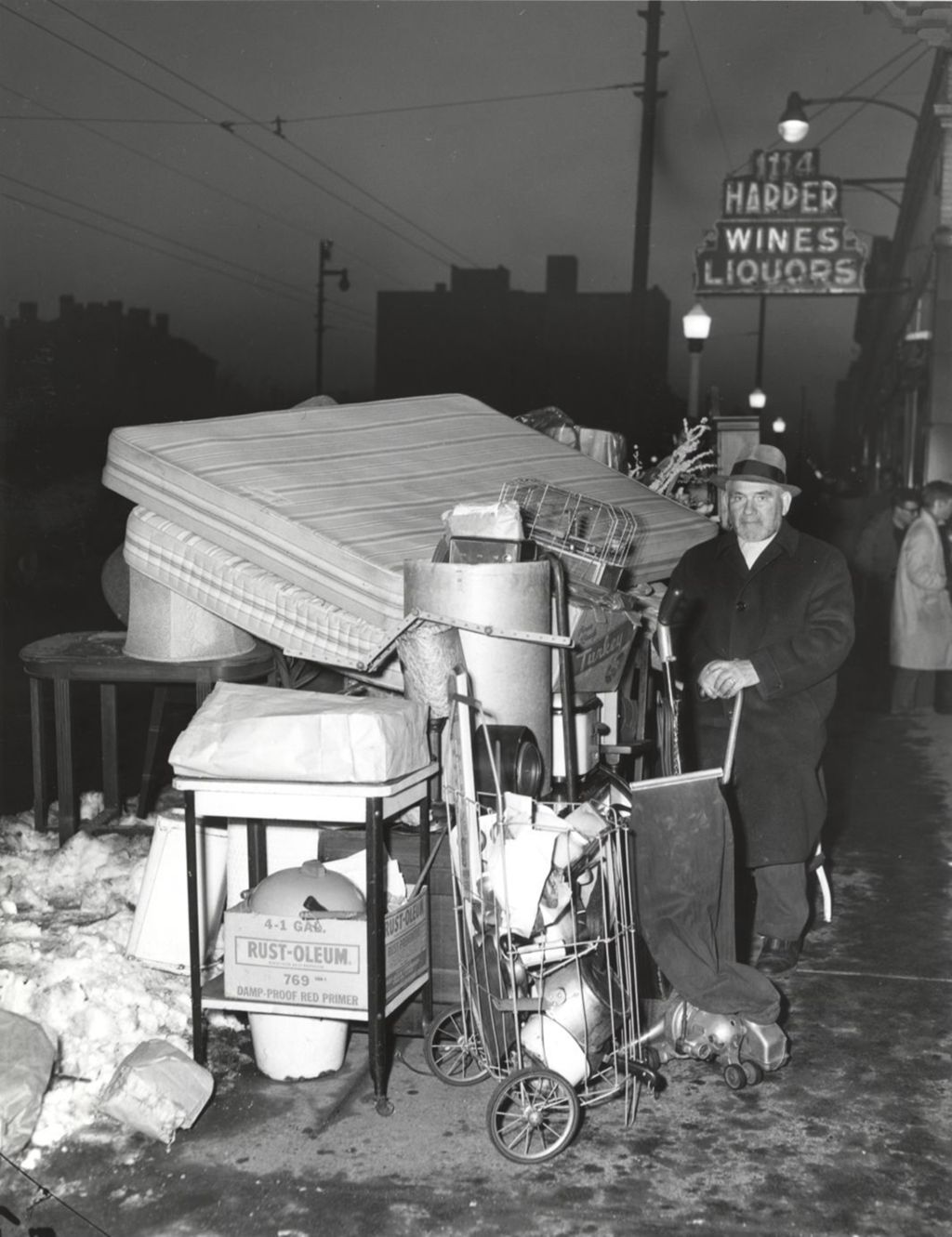 Man on sidewalk with household possessions