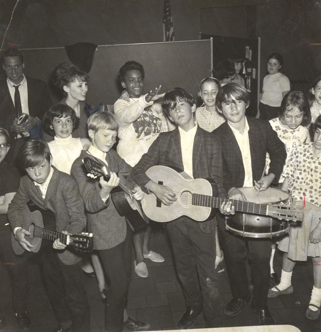 Boys with musical instruments in front of a crowd