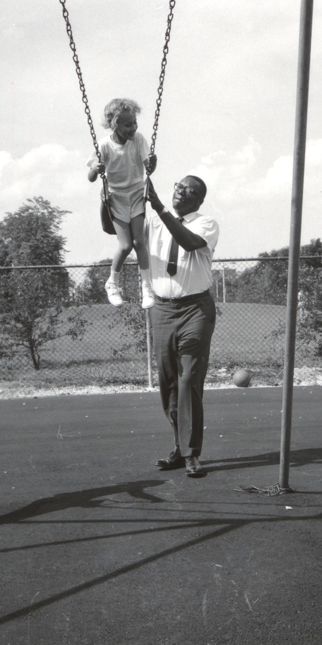 Man pushing a child on a swing