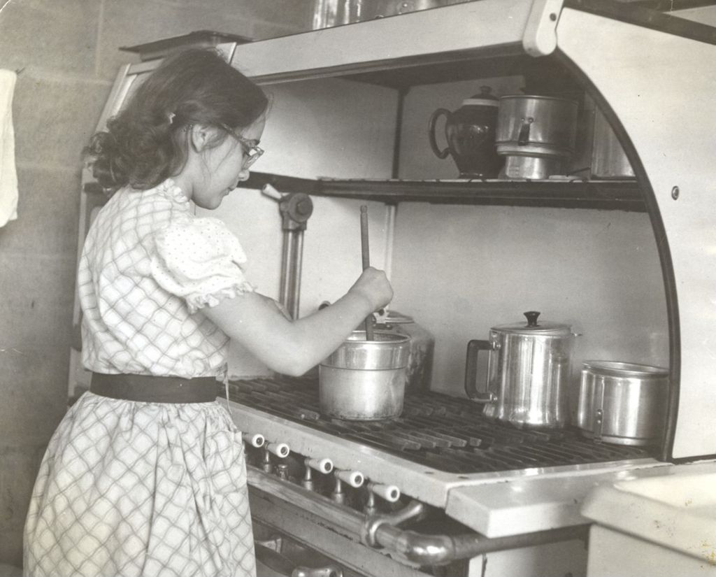 Young woman stirring a pot on a stove
