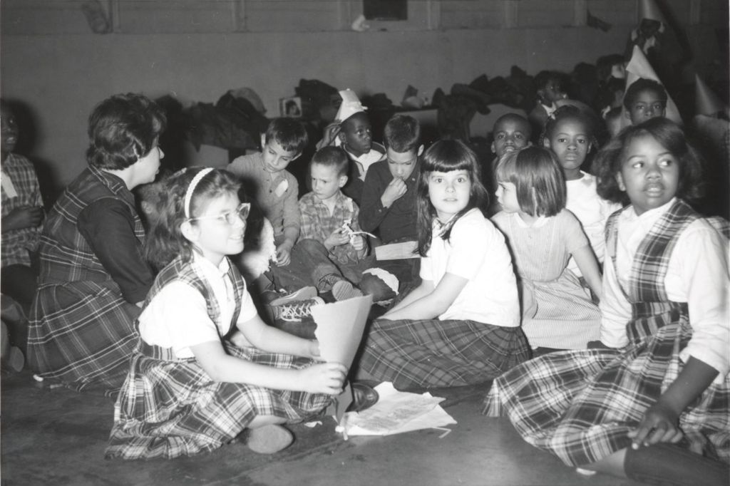 Children seated on the floor with their craft projects