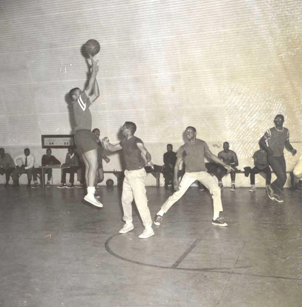 Teenagers playing basketball in a gymnasium