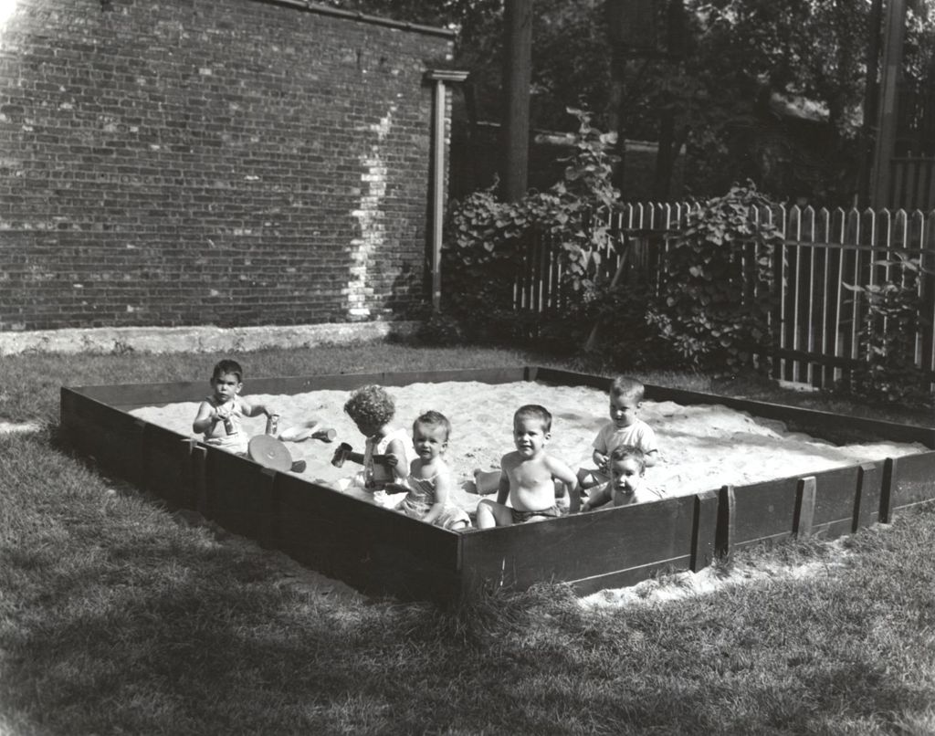 Young children playing in a large sandbox