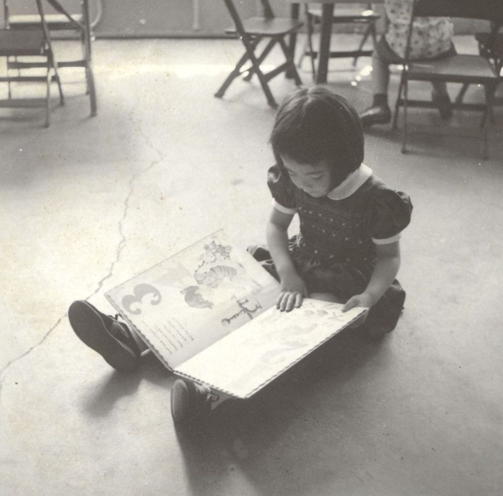 Miniature of Young Asian girl reading a book