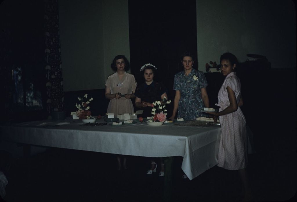 Women serving cake at a table