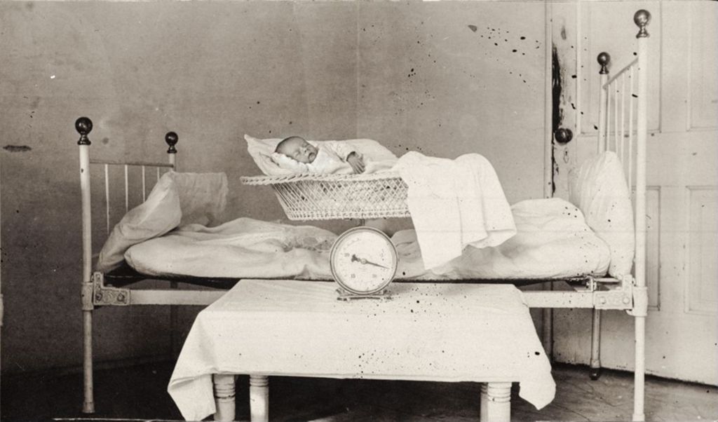 Infant in bassinet with scale