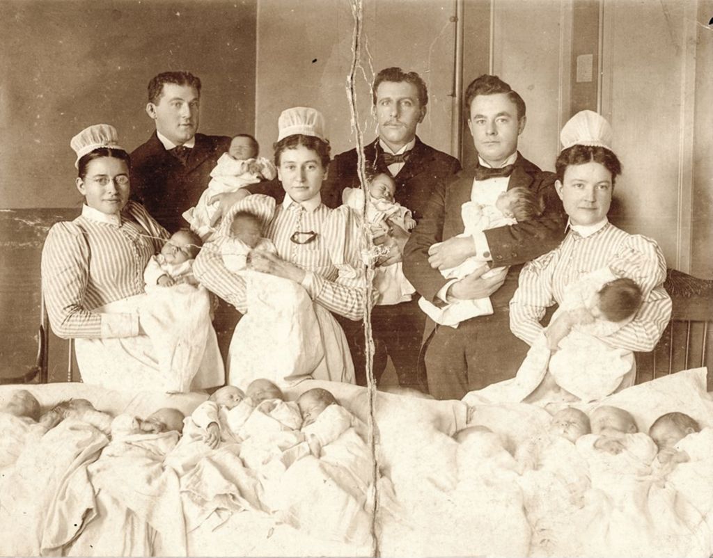 Medical staff with infants in maternity ward