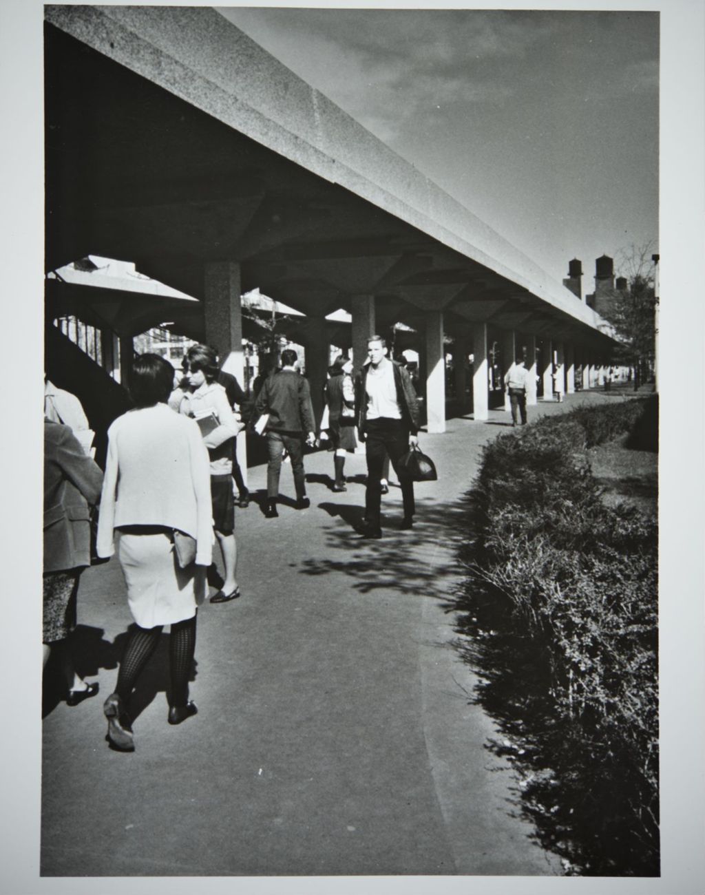 Students walking underneath the elevated walkways on campus