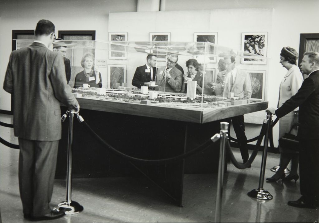 Miniature of People viewing a model for the construction of a new campus