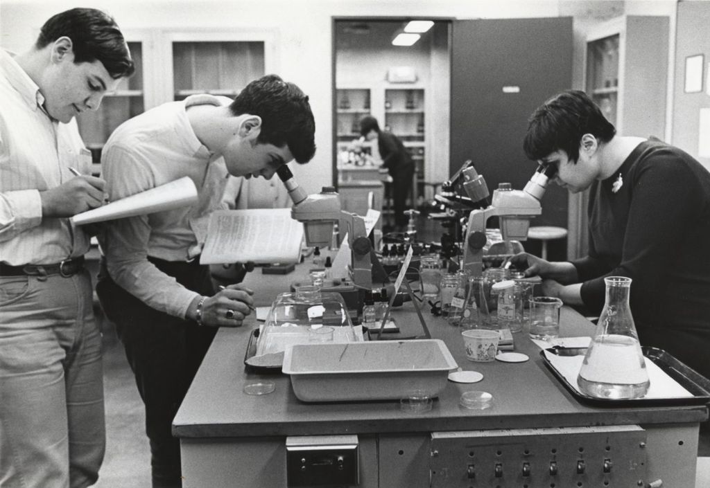 Miniature of Students looking into microscopes in a science lab